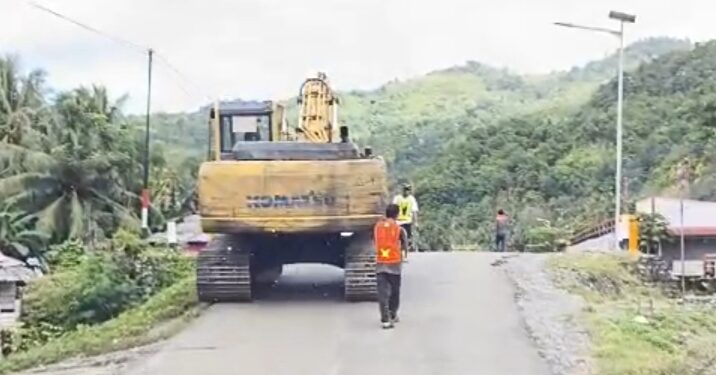 Excavator Melintasi Jalan Trans-sulawesi tepat di Pemukiman Warga Desa Tuntung, Kecamatan Bunta, Kabupaten Banggai.
(Gambar : Screenshot vidio Samiun L Agi.)