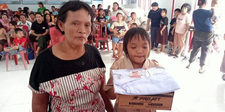 Murid SD Gonohop di Dampingi orang tuanya menerima bantuan seragam sekolah di kantor desa Gonohop, kecamatan Simpang Raya, Kabupaten Banggai.(Dok.istimewah)