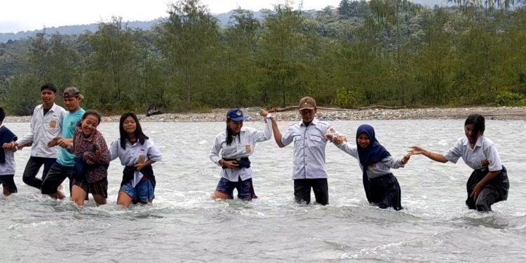 Sejumlah siswa-siswi asal Desa Masungkang, Kecamatan Batui Selatan, Kabupaten Banggai nekat bertaruh nyawa menyebrangi sungai untuk bisa sekolah di SMP Satu Atap Desa Ondo-ondolu, Kecamatan Batui. (Sumber: TribunPalu.com)