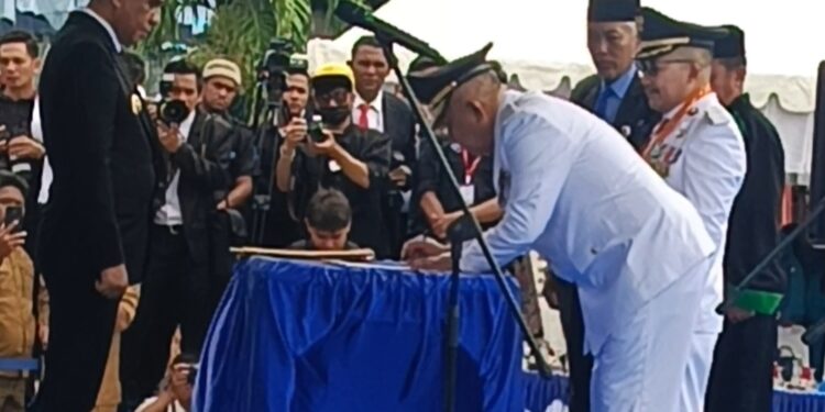 Amirudin Tamoreka dan Furqanudin Masulili saat penandatanganan berita acara pelantikan. ( Dok.Kilasbanggai.com)